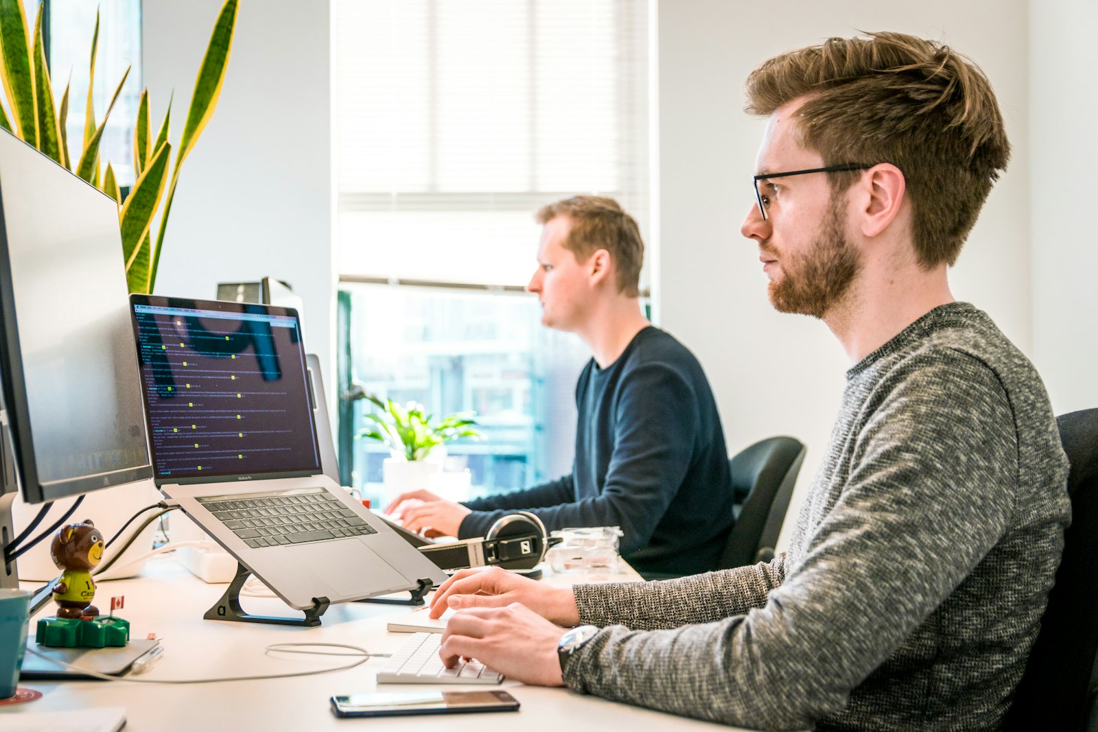 Zwei Entwickler arbeiten an ihren Bildschirmen