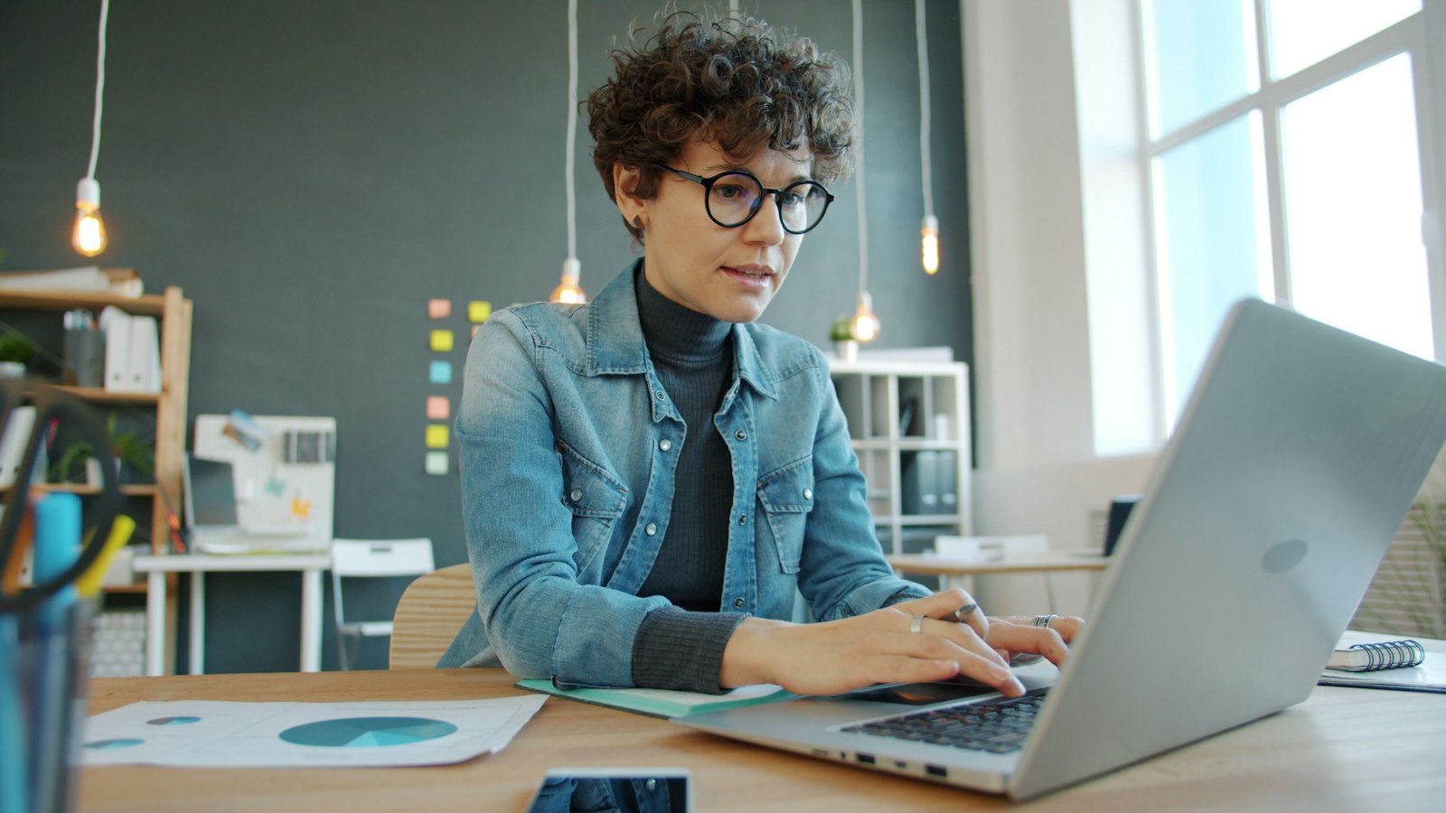 Person schreibt am Laptop in einem hellen Büro